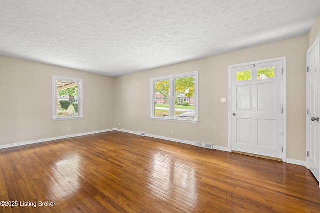 foyer entrance with wood-type flooring and a textured ceiling