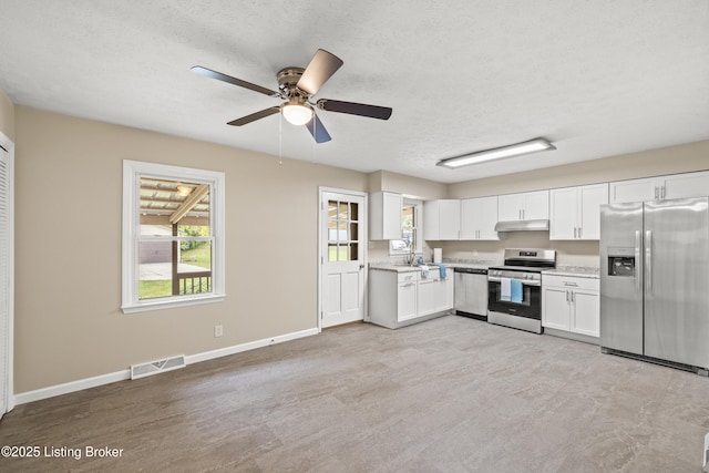 kitchen with ceiling fan, stainless steel appliances, a textured ceiling, and white cabinets