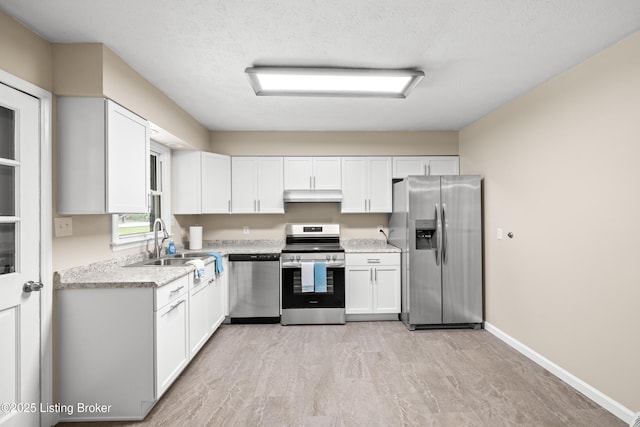 kitchen featuring stainless steel appliances, sink, white cabinets, and a textured ceiling