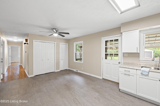 kitchen with white cabinetry, sink, and plenty of natural light