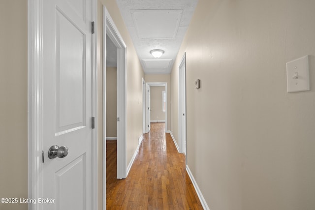 corridor with hardwood / wood-style flooring and a textured ceiling