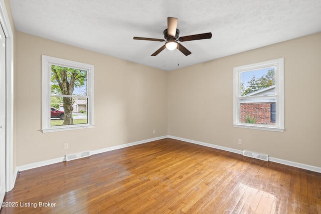 unfurnished room featuring ceiling fan, a textured ceiling, and light wood-type flooring