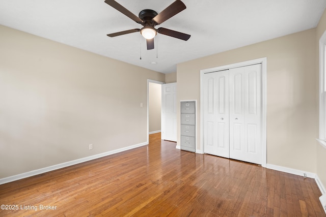 unfurnished bedroom with ceiling fan, wood-type flooring, and a closet