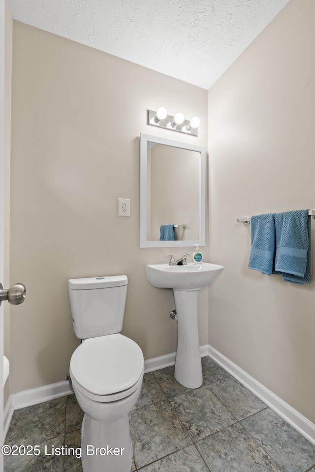 bathroom with sink, a textured ceiling, and toilet