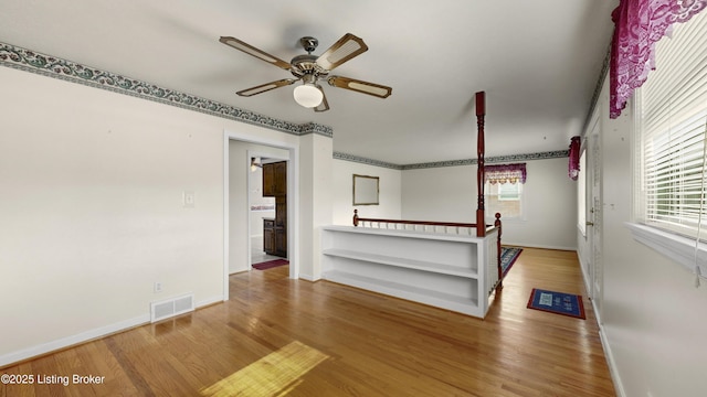 unfurnished living room with ceiling fan and hardwood / wood-style floors