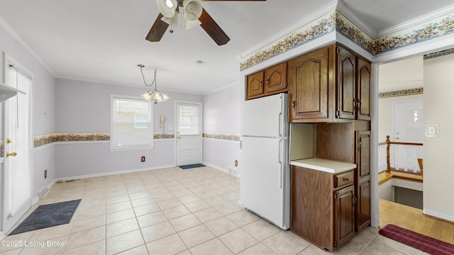 kitchen featuring white refrigerator, decorative light fixtures, and crown molding