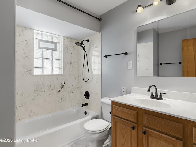 full bathroom featuring tiled shower / bath, vanity, and toilet