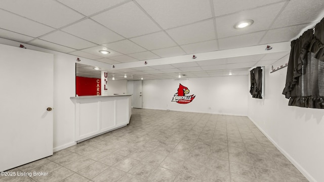 basement with bar area and a drop ceiling