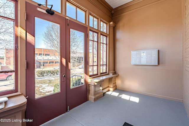 entryway with concrete flooring, a wealth of natural light, and mail boxes