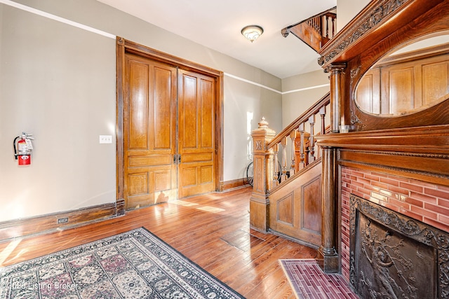 foyer featuring a brick fireplace and light hardwood / wood-style flooring