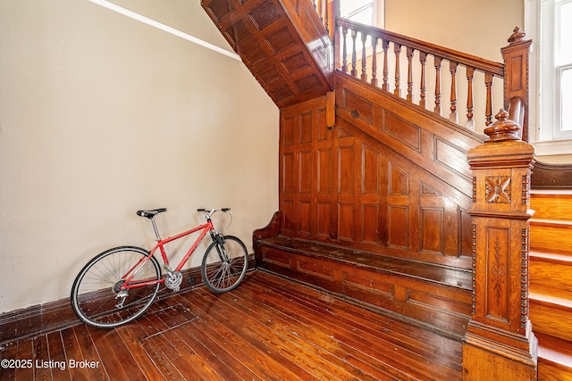 stairway with hardwood / wood-style floors and vaulted ceiling