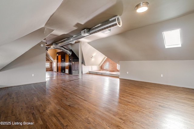 additional living space featuring hardwood / wood-style floors and vaulted ceiling