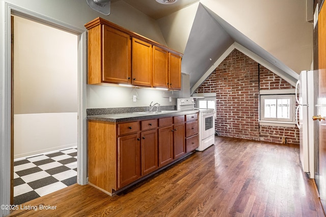 kitchen featuring brick wall, dark hardwood / wood-style floors, lofted ceiling, sink, and white appliances