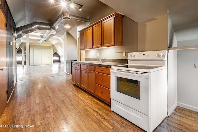 kitchen with sink, electric range, rail lighting, and light wood-type flooring