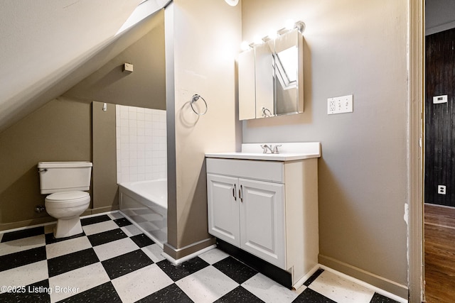 bathroom with a tub to relax in, vanity, toilet, and lofted ceiling