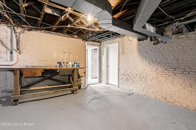 basement with brick wall and a workshop area