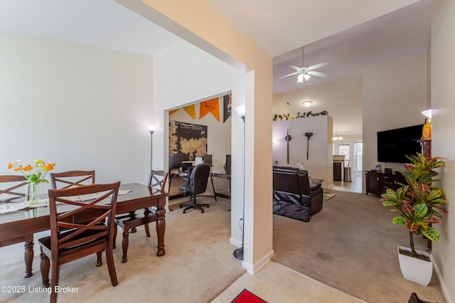 dining room featuring light carpet, high vaulted ceiling, and ceiling fan