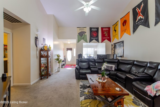 carpeted living room featuring a towering ceiling and ceiling fan