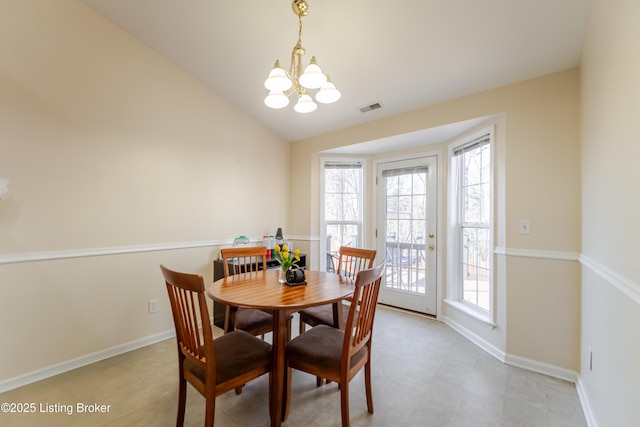 dining room with vaulted ceiling and a notable chandelier