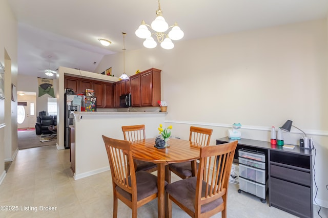 dining area featuring ceiling fan with notable chandelier and vaulted ceiling