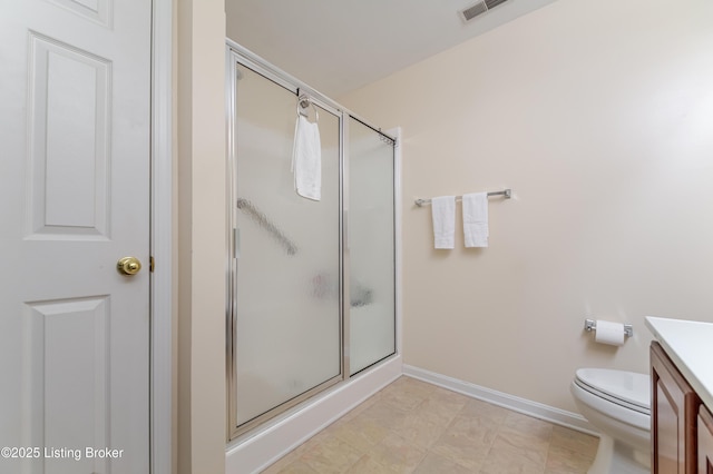 bathroom with vanity, toilet, and a shower with shower door