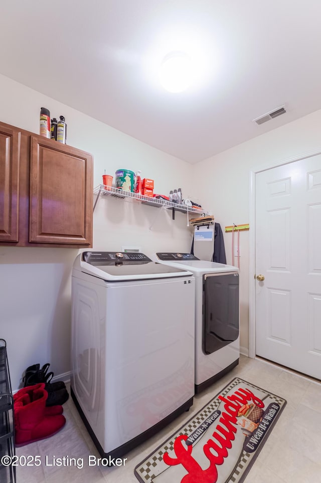 washroom featuring washer and clothes dryer and cabinets