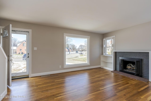 unfurnished living room with dark hardwood / wood-style floors and a fireplace