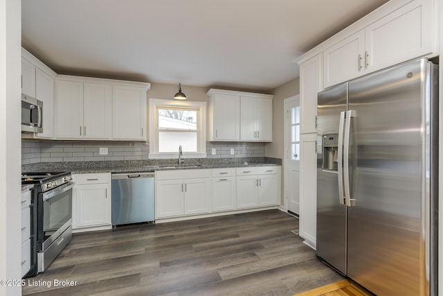 kitchen with tasteful backsplash, sink, white cabinets, and appliances with stainless steel finishes