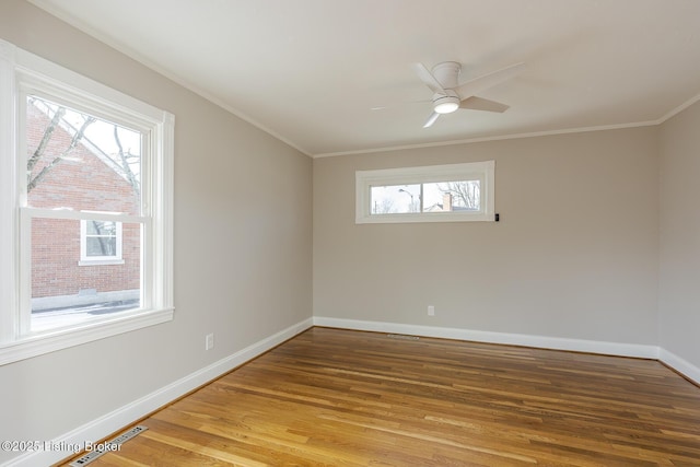 empty room with hardwood / wood-style flooring, ceiling fan, and crown molding