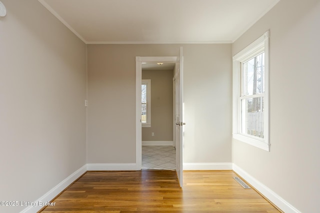 empty room with crown molding and wood-type flooring