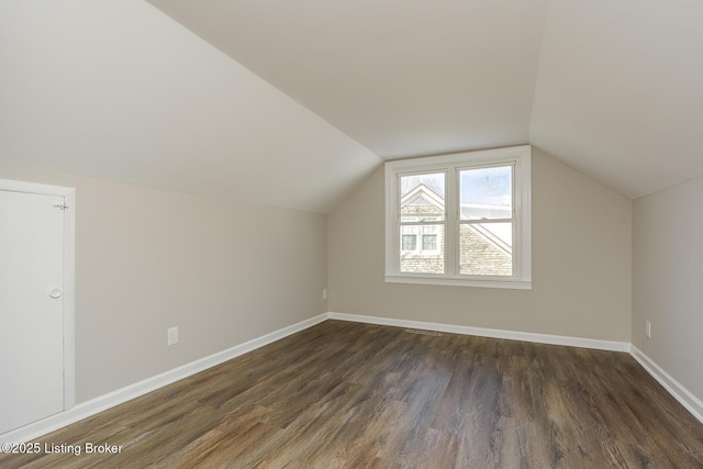 additional living space with lofted ceiling and dark hardwood / wood-style floors