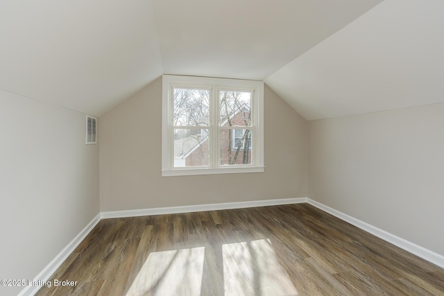 additional living space featuring lofted ceiling and dark hardwood / wood-style floors