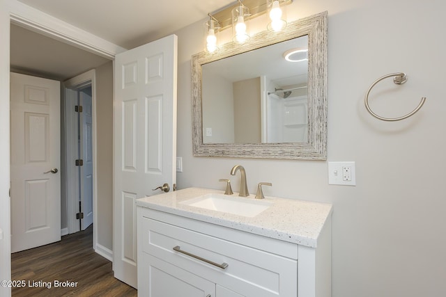 bathroom featuring hardwood / wood-style flooring, vanity, and a shower