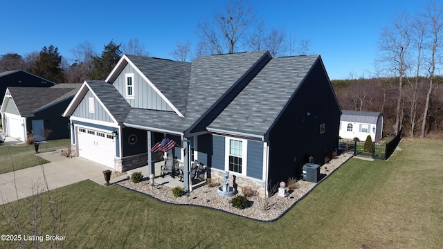 view of front of property featuring central AC unit, a garage, and a front lawn