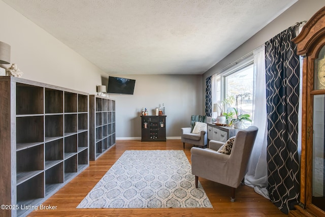 sitting room with hardwood / wood-style flooring and a textured ceiling