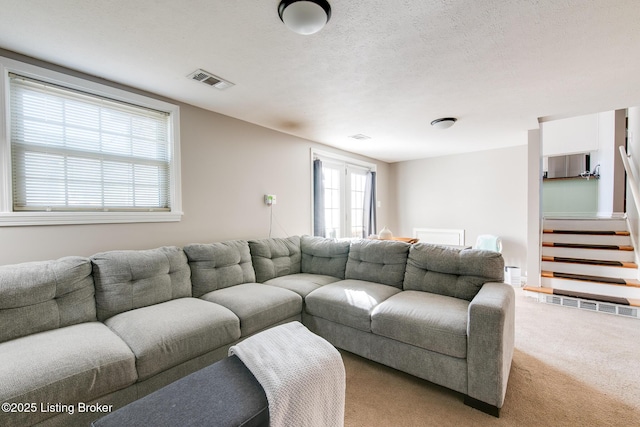 carpeted living room with a textured ceiling