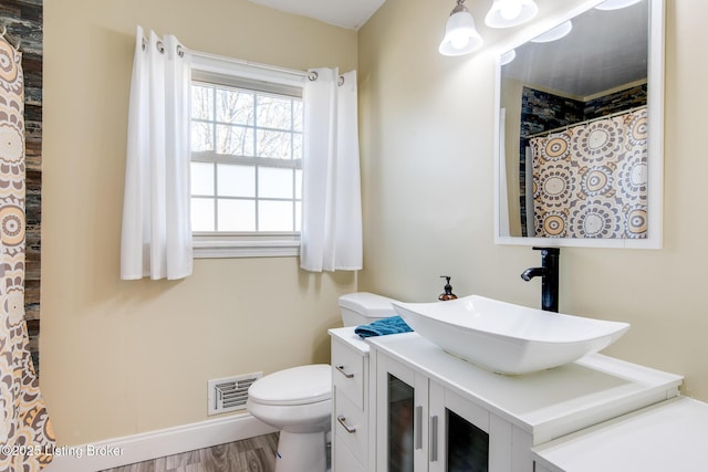 bathroom with hardwood / wood-style flooring, vanity, and toilet