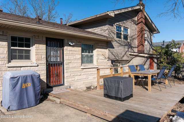 rear view of property featuring a wooden deck