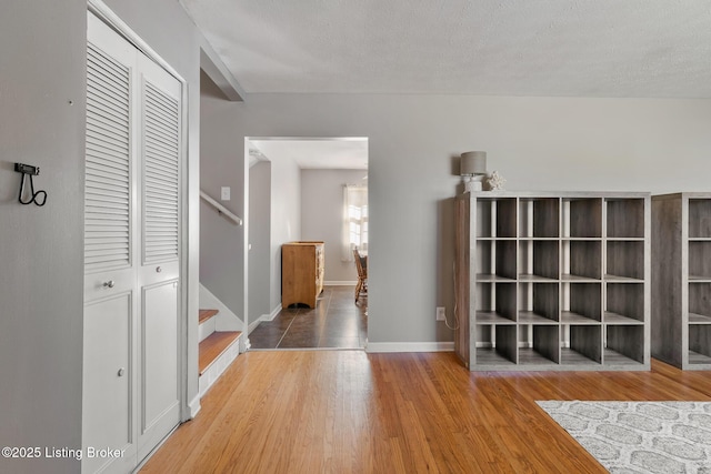 corridor with hardwood / wood-style floors and a textured ceiling