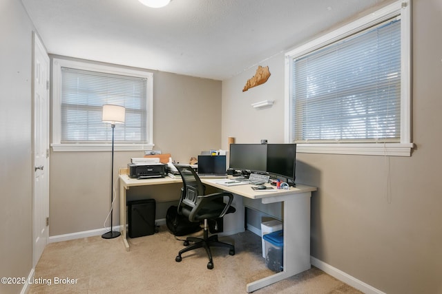 office area with plenty of natural light and light colored carpet