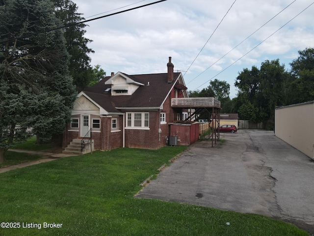 view of front of home featuring a front lawn and central air condition unit