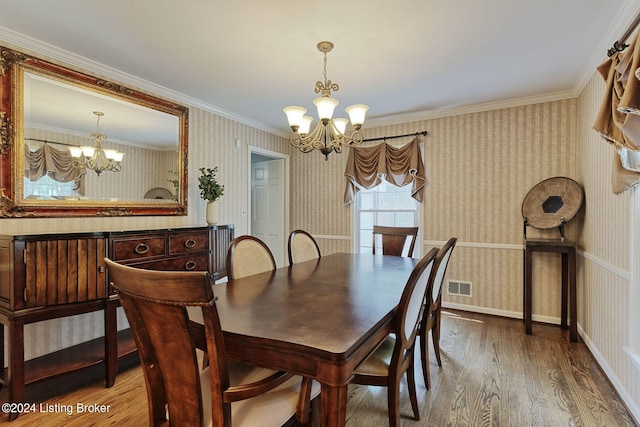 dining space with crown molding, wood-type flooring, and a notable chandelier