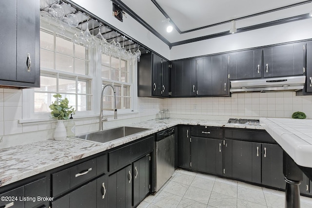 kitchen featuring rail lighting, sink, light tile patterned floors, dishwasher, and decorative backsplash