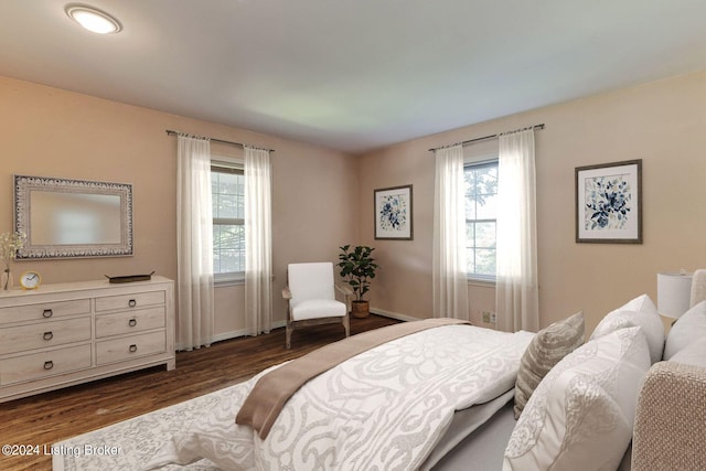 bedroom with dark wood-type flooring and multiple windows