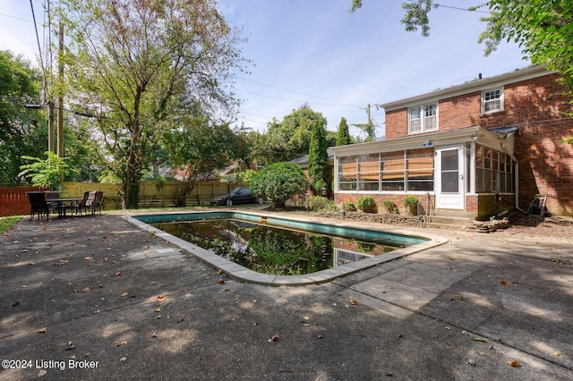 view of pool with a patio and a sunroom