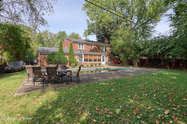 back of house with a fenced in pool, a yard, and a patio