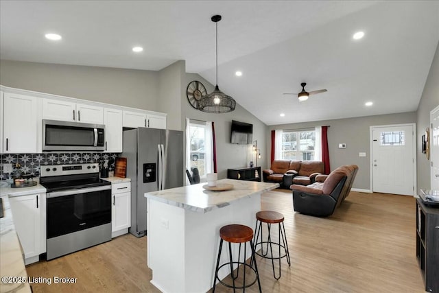 kitchen featuring white cabinetry, appliances with stainless steel finishes, and decorative light fixtures