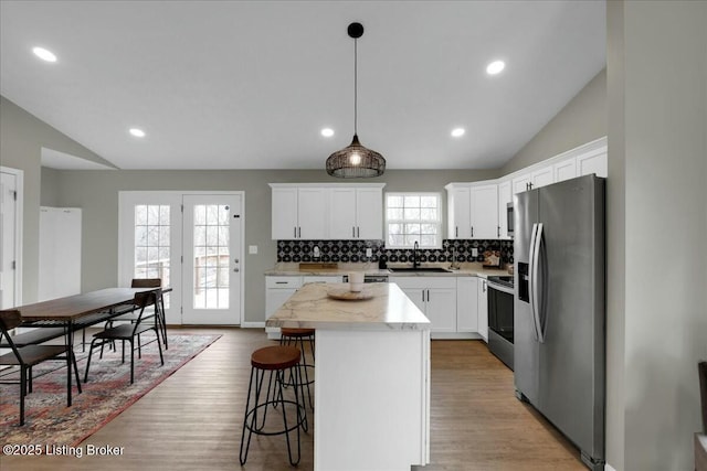 kitchen featuring sink, a kitchen island, white cabinets, and appliances with stainless steel finishes