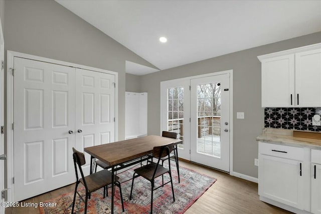 dining area with vaulted ceiling and light hardwood / wood-style flooring