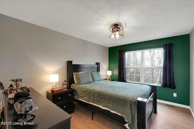 bedroom with hardwood / wood-style flooring and a textured ceiling